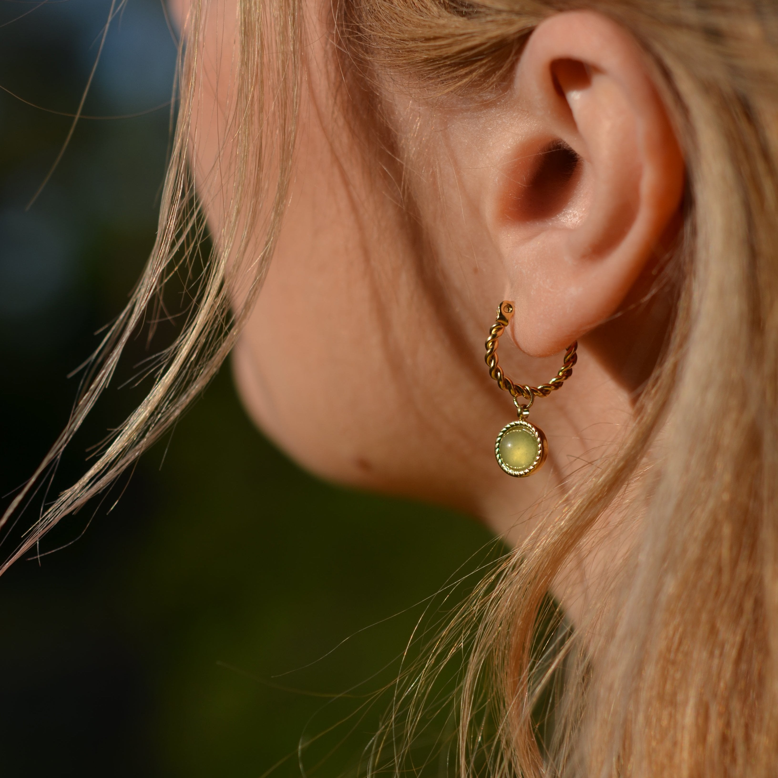 a woman wearing green jade jewelry, jade earrings