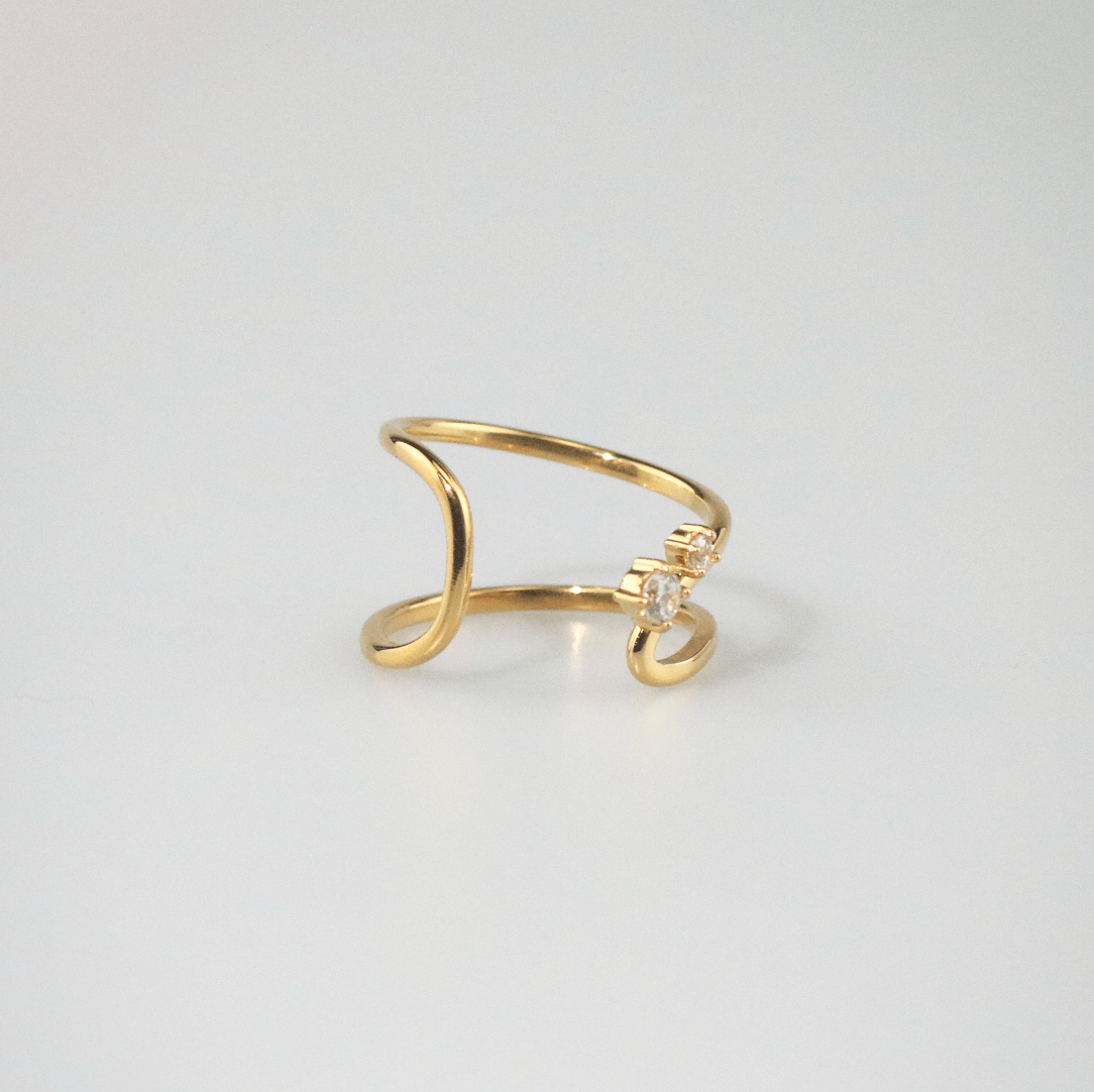 Gold ring with a small diamond on a light gray background