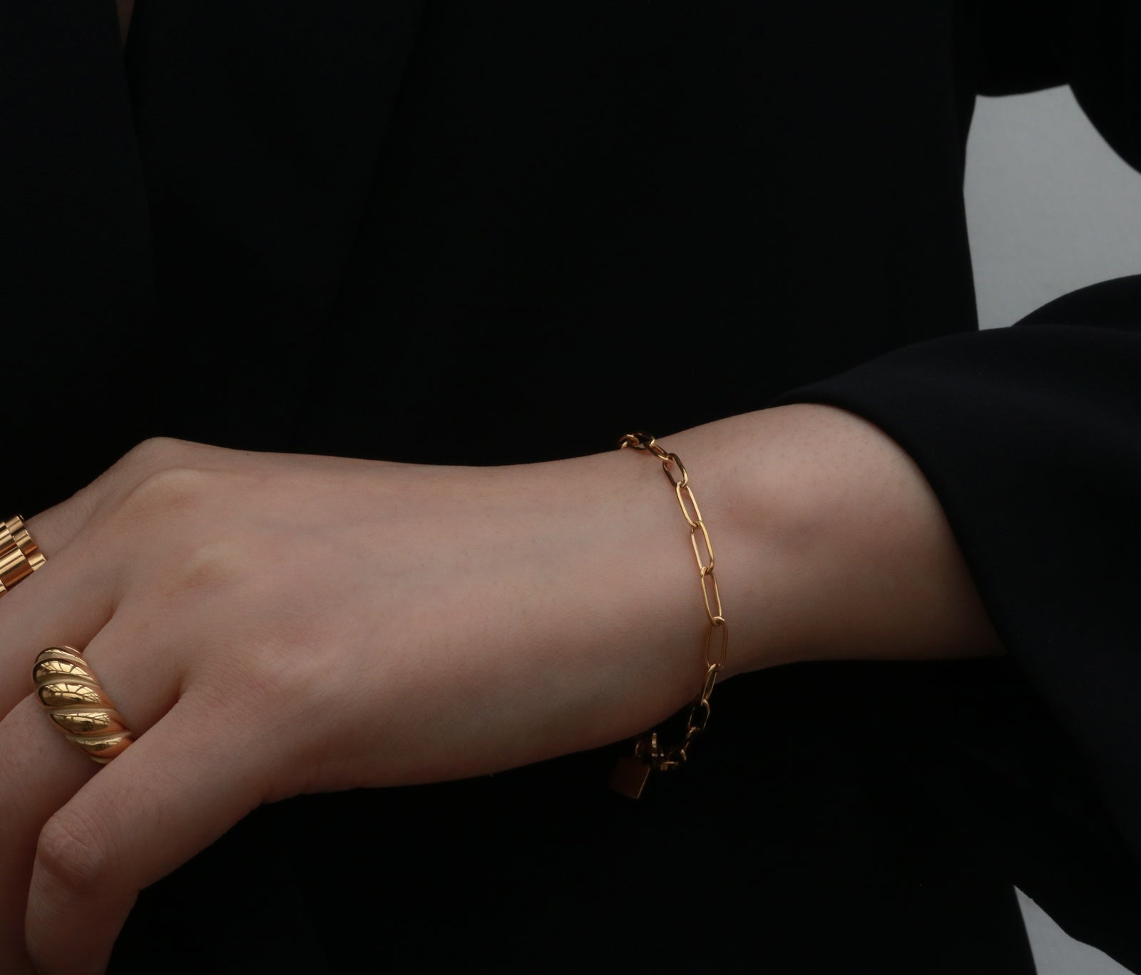 Women wearing gold rings and a link chain bracelet